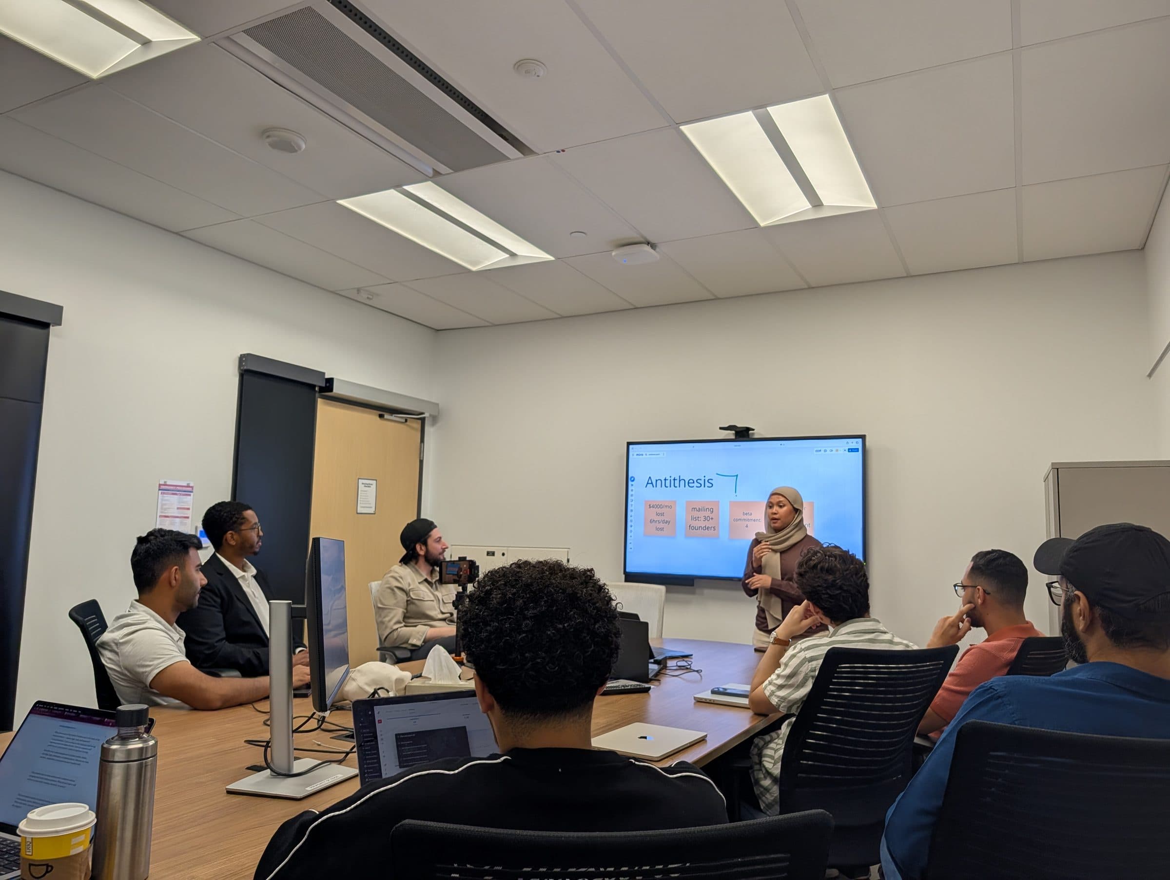 A founder presenting to the cohort, with working notes on the screen.